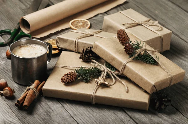 Vánoční dárky s šálkem cappuccina na dřevěný stůl — Stock fotografie