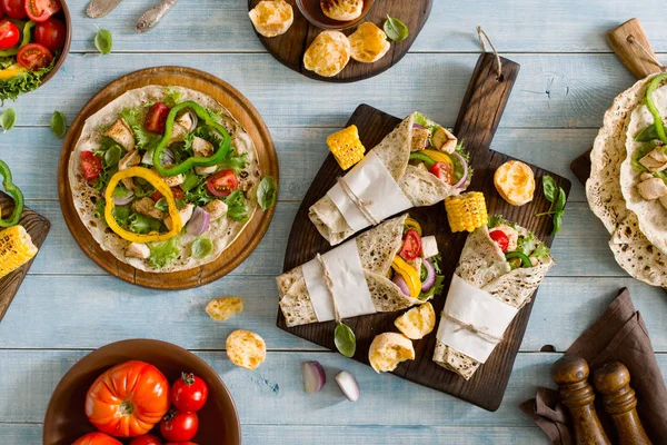 Roll tortilla with grilled chicken fillet on wooden cutting boar — Stock Photo, Image