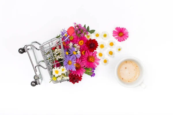 Warenkorb voller verschiedener Wildblumen mit Tasse Kaffee — Stockfoto