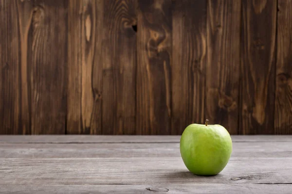Зеленое яблоко на деревянном столе — стоковое фото