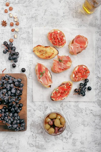 Different snacks for wine on rough white surface — Stock Photo, Image