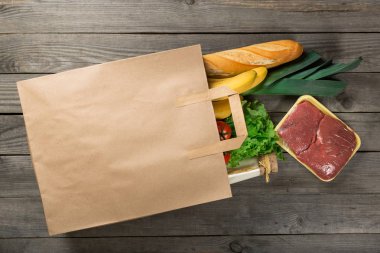 Kağıt torba ahşap arka plan üzerinde farklı gıda