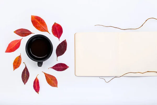 Open Kladblok met vallende herfstbladeren en kopje koffie — Stockfoto