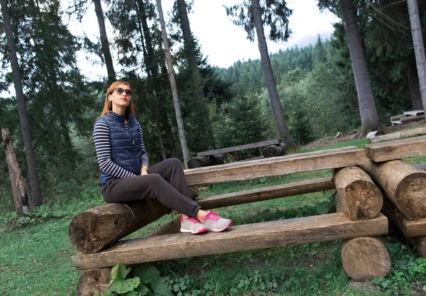 Mladá krásná žena sedící na lavičce venku těší mom — Stock fotografie