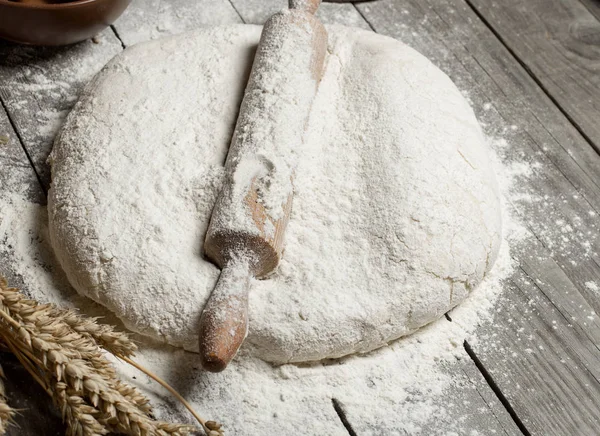 Rolling pin with flour and wheat on wooden table — Stock Photo, Image