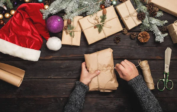 남자 나무 테이블에 크리스마스 선물 포장 — 스톡 사진