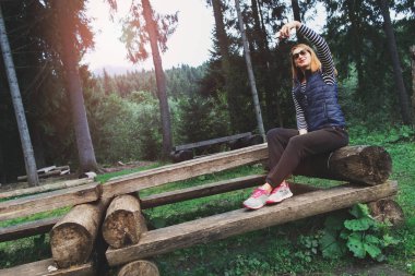 Sunset bulvarında bankta oturan selfie yapma kadın