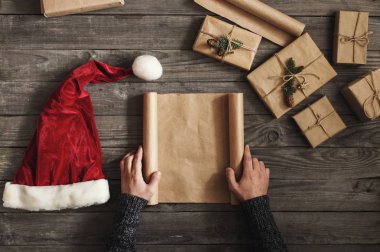 Boş kağıt yaprağının ahşap masa üzerinde tutan adam