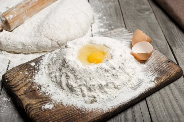 La yema de huevo en la harina en la mesa de madera en la panadería —  Fotos de Stock