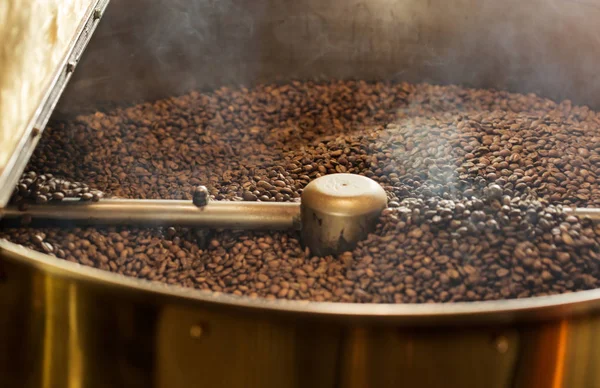 Dunkle Kaffeebohnen in professioneller Röstmaschine — Stockfoto