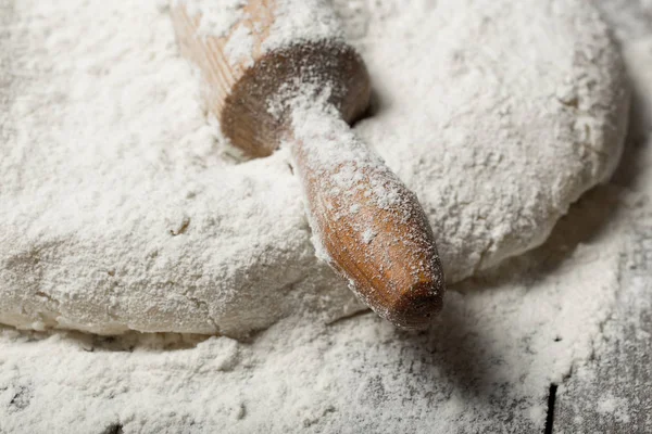 Rolling pin with flour on wooden table in bakery — Stock Photo, Image