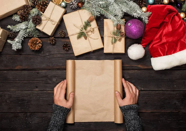 Mano masculina sosteniendo hoja de papel en blanco sobre mesa de madera — Foto de Stock