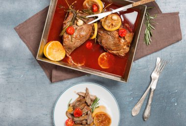 Kızarmış biftek domates, limon, sarımsak ve biberiye tencerede