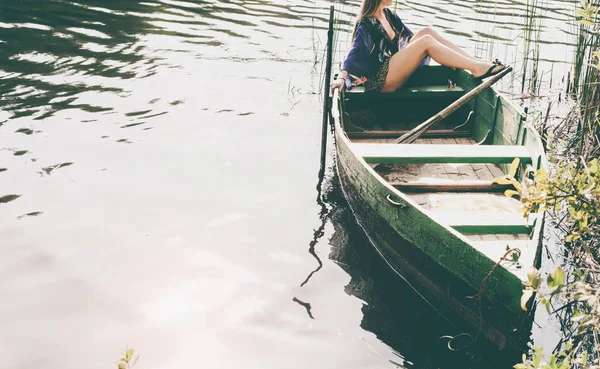 Женщина сидит в лодке и наслаждается моментами расслабления — стоковое фото