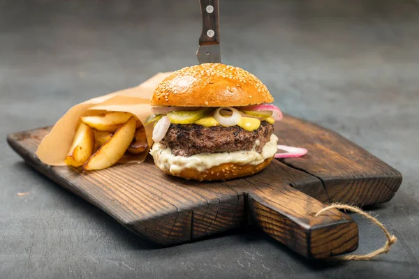 古い基板のフライド ポテトと新鮮なハンバーガー — ストック写真