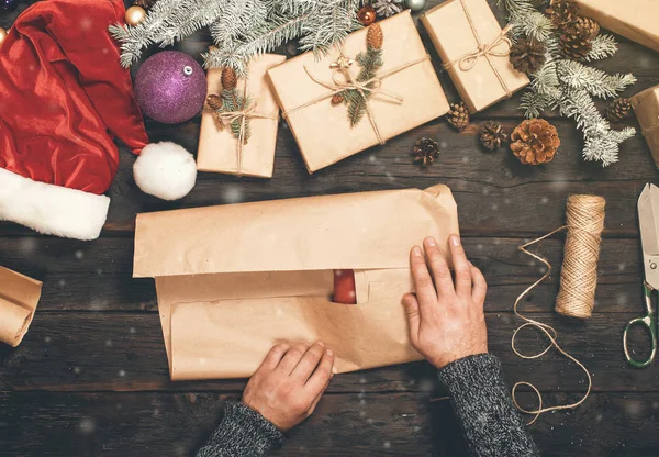男の手が紙でクリスマス プレゼントをラップ — ストック写真
