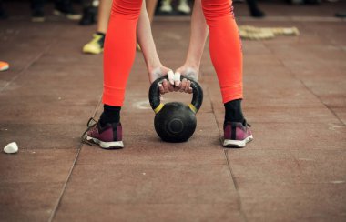 Kadın atlet bir kettlebell tutarak yakın çekim