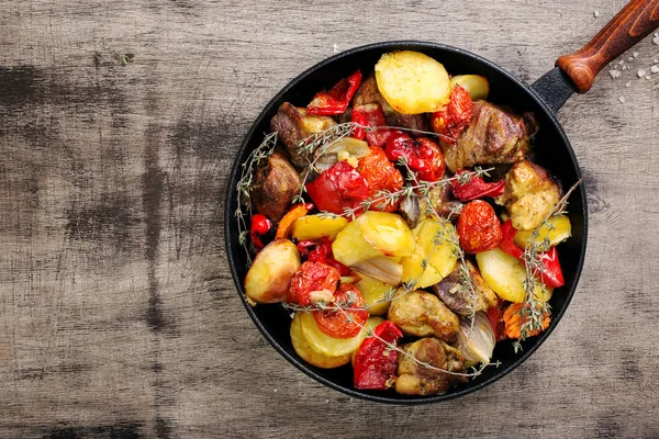 Жареное мясо с овощами в чугунной сковороде — стоковое фото