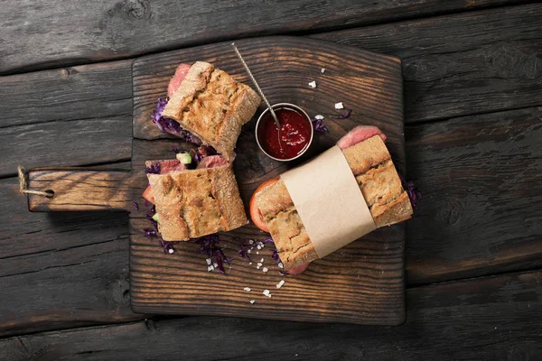 Сэндвич с говядиной на тёмном деревянном столе — стоковое фото