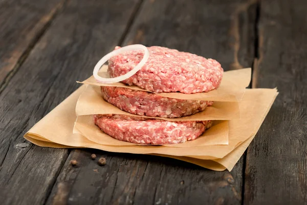 Raw ground beef meat cutlets with onion ring — Stock Photo, Image