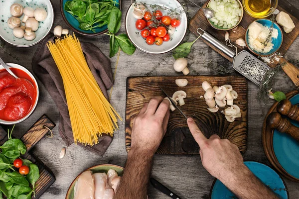 Чоловічі руки готують інгредієнти для макаронів на дерев'яному столі — стокове фото