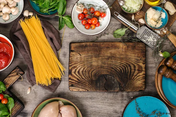 Tablero de cocina con espagueti crudo e ingredientes para cocinar pas — Foto de Stock