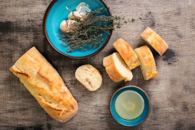 Yağ, sarımsak ve kekik ile ahşap masa üzerinde İtalyan baget