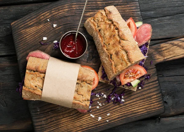 Сэндвич с говядиной на гриле на деревянной доске — стоковое фото