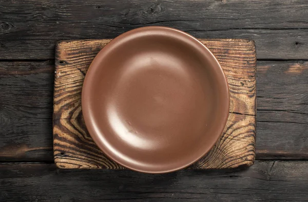 Assiette vide vintage marron sur une vieille planche à découper — Photo