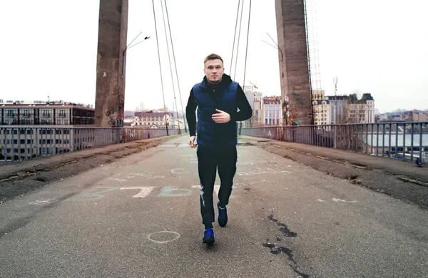 Joven corredor corriendo por la carretera puente de la ciudad — Foto de Stock