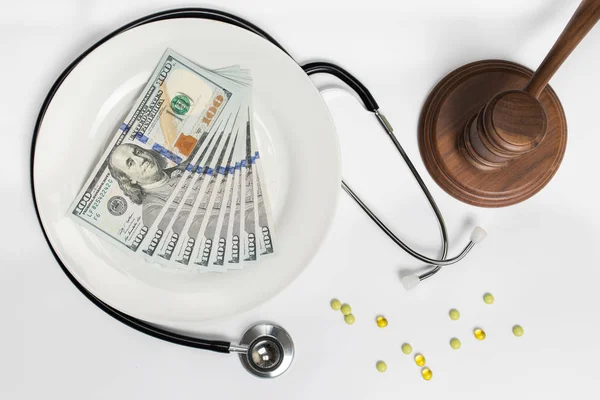 Geldstapel mit Richterhammer, Tabletten und medizinischem Stethoskop — Stockfoto