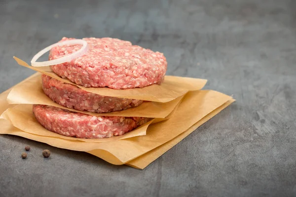 Raw ground beef meat cutlets on a stone surface — Stock Photo, Image