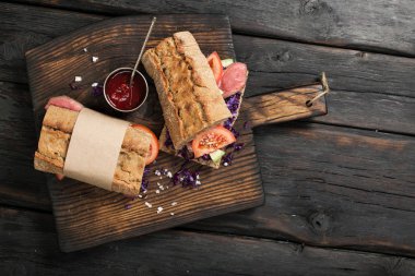 Bir ahşap tahta masada sığır etli sandviç