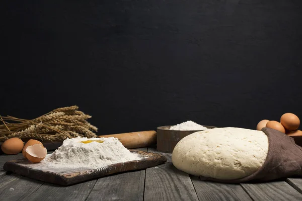 Fresh dough with flour and eggs on wooden table — Stock Photo, Image