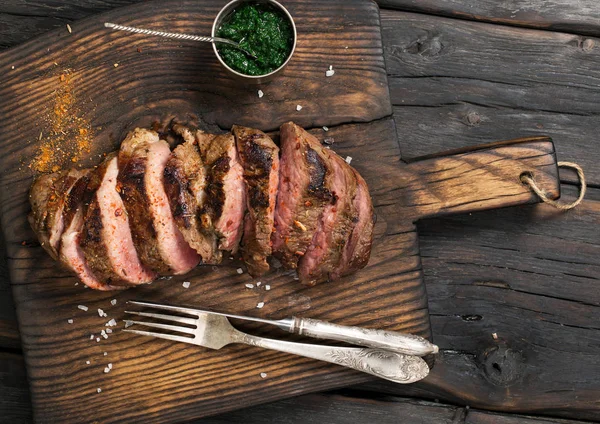 Fette di bistecca di manzo sul vecchio tagliere — Foto Stock