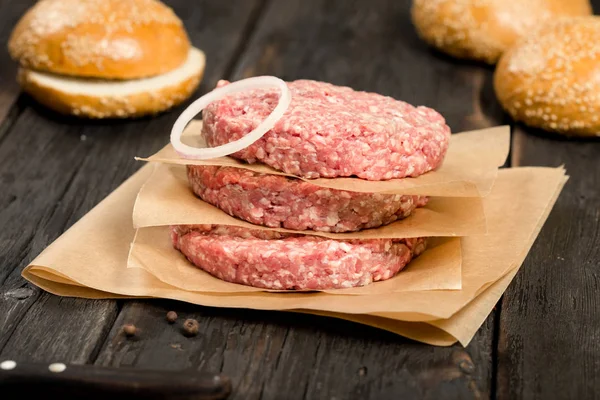 Closeup fresh raw ground beef meat cutlets with onion ring — Stock Photo, Image