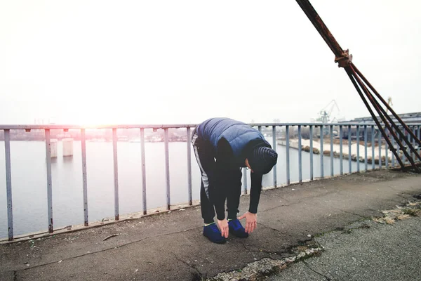 Hombre de fitness haciendo ejercicio en un puente de la ciudad — Foto de Stock