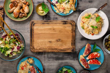 Doğrama tahtası, risotto, kavrulmuş tavuk budu ve aperatifler