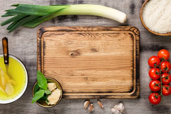 Ingredientes para cozinhar risoto em torno da placa de corte em t de madeira — Fotografia de Stock