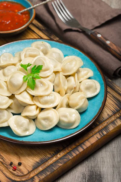 Ravioli with red sauce on dark wooden table — Stock Photo, Image