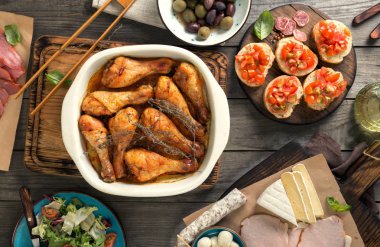 Pişmiş tavuk budu ile çeşitli ahşap masa snacks
