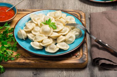 Bir ahşap tahta üzerinde kırmızı bir soslu Ravioli