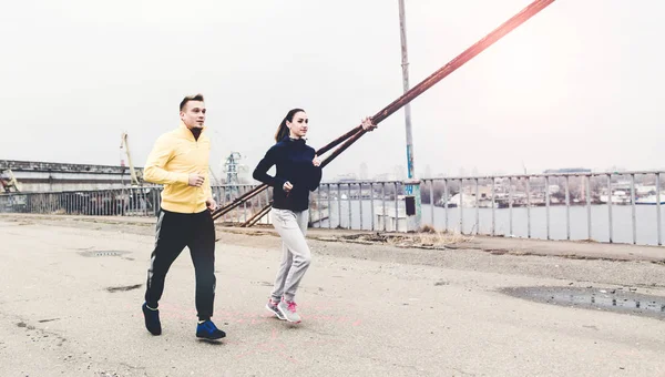 Amigos corriendo en un puente de la ciudad en un día nublado — Foto de Stock