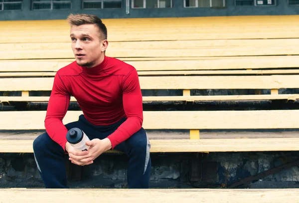 Un atleta descansando en el banco — Foto de Stock