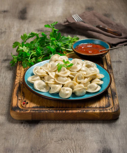 A plate wuth boiled ravioli on the wooden board — Stock Photo, Image