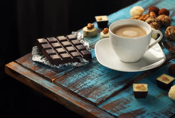 Taza de café con barra de chocolate y variedad de dulces — Foto de Stock