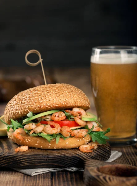 Burger with grilled shrimp and a glass of light beer — Stock Photo, Image