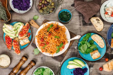 Ahşap masa üzerinde farklı İtalyan yemekleri ile makarna