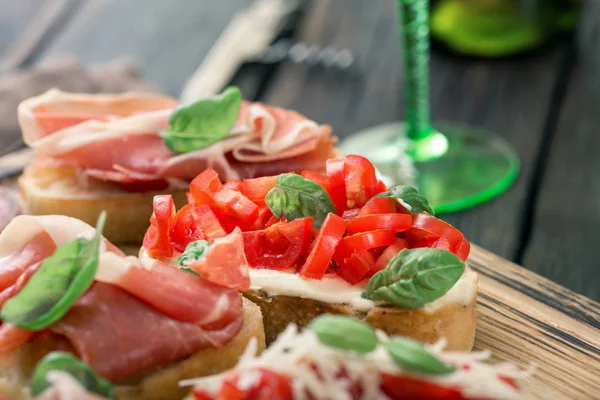 Variety small sandwiches with prosciutto, tomatoes, fresh basil — Stock Photo, Image