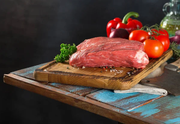 Carne de res cruda con verduras en una mesa de madera — Foto de Stock